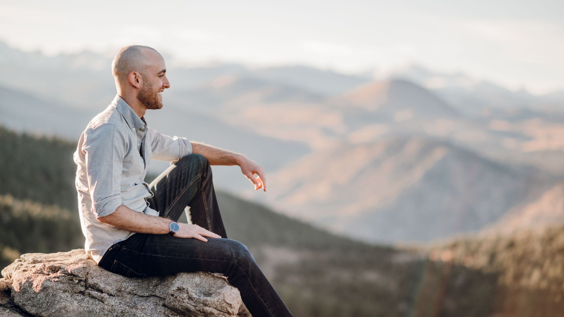 Jason sitting on a rock in the mountains